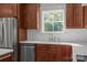 The kitchen features wood cabinets, stainless steel appliances, granite countertops, and white tile backsplash at 108 Woodwinds St, Locust, NC 28097