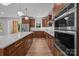 The kitchen boasts stainless steel appliances, wood cabinets, an island with a countertop, and hardwood floors at 108 Woodwinds St, Locust, NC 28097