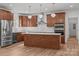 The kitchen features custom cabinets, an island with a marble countertop, and stainless steel appliances at 108 Woodwinds St, Locust, NC 28097