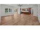 Open-concept living room flows into the kitchen, featuring wood flooring, recessed lighting, and natural light at 108 Woodwinds St, Locust, NC 28097