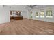 Open floor plan with spacious living area and access to the kitchen, filled with natural light and wood flooring at 108 Woodwinds St, Locust, NC 28097