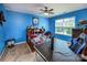 Bright bedroom features a colorful comforter, a ceiling fan, and a large window for natural light at 134 Cherry Bark Dr, Mooresville, NC 28117