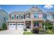 Charming two-story home featuring a brick and brown siding, a two-car garage and an inviting front porch at 134 Cherry Bark Dr, Mooresville, NC 28117