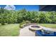Lush backyard featuring a stone fire pit, patio seating, and privacy landscaping, perfect for outdoor living at 134 Cherry Bark Dr, Mooresville, NC 28117