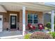 Inviting covered front porch with brick pillars, comfortable seating, and stylish decor that exudes curb appeal at 134 Cherry Bark Dr, Mooresville, NC 28117