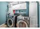 Modern laundry room featuring a side-by-side washer and dryer, white cabinetry, and ample storage space at 134 Cherry Bark Dr, Mooresville, NC 28117