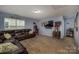 Cozy media room boasts a large, comfortable leather sectional, movie theater decor, and a wall-mounted television at 134 Cherry Bark Dr, Mooresville, NC 28117