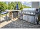 Outdoor kitchen with stone countertop, built-in grill, mini fridge, and bar seating in a private backyard at 134 Cherry Bark Dr, Mooresville, NC 28117
