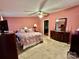 This main bedroom features light pink walls and carpet, and dark brown furniture at 1341 Pleasant Hill Church Rd, Wadesboro, NC 28170