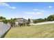 Expansive backyard featuring a playset, white fence and covered patio perfect for outdoor entertaining at 159 E Warfield Dr, Mooresville, NC 28115