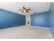 Spacious bedroom featuring plush carpeting, ceiling fan and neutral wall paint at 159 E Warfield Dr, Mooresville, NC 28115