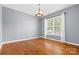 A bright dining room features gleaming hardwood floors, neutral walls, and a modern chandelier at 159 E Warfield Dr, Mooresville, NC 28115