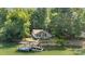 Aerial view of a beautiful lakefront home with mature trees, a boat dock, and a relaxing outdoor space at 208 Island View Rd, Mount Holly, NC 28120