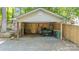 Open carport with gravel floor providing ample space for vehicles and storage near a wooden fence at 208 Island View Rd, Mount Holly, NC 28120