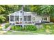Waterfront home boasts a screened porch, deck with seating, and a hot tub, all set against a backdrop of trees at 208 Island View Rd, Mount Holly, NC 28120