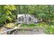 Beautiful waterfront home with a screened porch, deck, and dock, surrounded by lush greenery and mature trees at 208 Island View Rd, Mount Holly, NC 28120