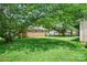 Spacious backyard featuring a lush lawn, mature trees, and a classic brick home at 2215 Hodgin St, Gastonia, NC 28056