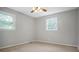 A carpeted room with a neutral gray color palette, and natural light from two windows and a ceiling fan at 2215 Hodgin St, Gastonia, NC 28056