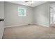 A carpeted room with a neutral gray color palette, and natural light from a window at 2215 Hodgin St, Gastonia, NC 28056