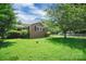 A quaint brick home with a lush lawn, mature trees, and chain link fence at 2215 Hodgin St, Gastonia, NC 28056
