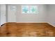 Hardwood floor and light filled living room with white door and trim at 2215 Hodgin St, Gastonia, NC 28056