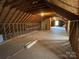 Partially finished attic with wooden framing and a small window at 2515 Myra Ln, Lincolnton, NC 28092