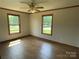 Bedroom with wood flooring, baseboard trim, ceiling fan, and two large windows at 2515 Myra Ln, Lincolnton, NC 28092