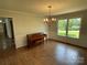 Elegant dining room features a chandelier, hardwood floors, and large windows with a piano at 2515 Myra Ln, Lincolnton, NC 28092