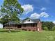 Brick home with a lush green lawn and mature trees offering shade and privacy at 2515 Myra Ln, Lincolnton, NC 28092