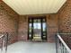 Charming brick home featuring a covered front porch with a decorative front door and metal railings at 2515 Myra Ln, Lincolnton, NC 28092
