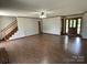 Open living room with hardwood floors, neutral walls, a staircase and a decorative front door at 2515 Myra Ln, Lincolnton, NC 28092