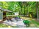 An expansive backyard features a stone patio, outdoor seating, lush landscaping and a play set beyond the utility shed at 2984 Starnes Dr, Rock Hill, SC 29730