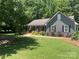 A cozy home featuring a metal roof and a beautifully landscaped front yard with a curving walkway at 3210 Crow Row, Monroe, NC 28112