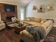 Comfortable living room with a brick fireplace, neutral sofa, and hardwood floors at 3210 Crow Row, Monroe, NC 28112