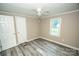Comfortable bedroom with durable floors, a ceiling fan, two doors, and a window at 34107 Watson Rd, Albemarle, NC 28001