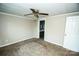 This bedroom features carpeted flooring, a door to a bathroom, and a ceiling fan at 34107 Watson Rd, Albemarle, NC 28001