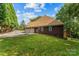 A view of the side of the home featuring a two-car garage, a basketball hoop, and a green lawn at 3916 2Nd Street Nw Dr, Hickory, NC 28601