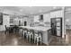 Spacious kitchen features a large island with seating, white cabinets, stainless steel appliances, and hardwood floors at 3916 2Nd Street Nw Dr, Hickory, NC 28601