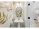 Stylish powder room featuring decorative wallpaper, pedestal sink, oval mirror, and trendy lighting fixture at 529 N Central Ave, Locust, NC 28097