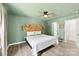 Cozy bedroom featuring wood floors, a ceiling fan, and a stylish herringbone headboard at 529 N Central Ave, Locust, NC 28097