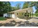 Charming white brick home featuring a covered carport and inviting entrance with mature trees in a landscaped yard at 617 Rock Hill Church Rd, Matthews, NC 28104