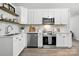 Well-lit kitchen with white cabinets, modern appliances, and stylish countertops at 617 Rock Hill Church Rd, Matthews, NC 28104