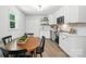 Eat-in kitchen boasts stainless appliances, floating shelves, white cabinets, and a wood table for four at 617 Rock Hill Church Rd, Matthews, NC 28104