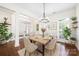 Bright dining room with modern chandelier, wainscotting and views to the backyard through French doors at 646 Quicksilver Trl # 183, Fort Mill, SC 29708