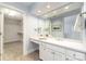 Bright bathroom featuring white cabinetry, a long vanity, a large mirror, and access to a walk-in closet at 6602 Gaywind Dr, Charlotte, NC 28226