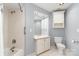 Bathroom with white tiled shower, vanity, medicine cabinet, and toilet against a light blue wall at 6602 Gaywind Dr, Charlotte, NC 28226