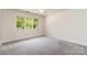 Bright bedroom with large windows and neutral carpet and trim; ceiling fan included at 6602 Gaywind Dr, Charlotte, NC 28226