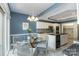 Open kitchen and dining area with an island, modern appliances, and a glass-top table with seating at 6602 Gaywind Dr, Charlotte, NC 28226