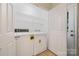 Well-lit laundry room with convenient overhead shelving for extra storage at 703 Dalebrook Ln, Rock Hill, SC 29730
