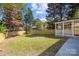 Lush backyard with mature trees, a wooden fence, and a covered porch area for outdoor enjoyment at 7219 Spring Morning Ln, Charlotte, NC 28227